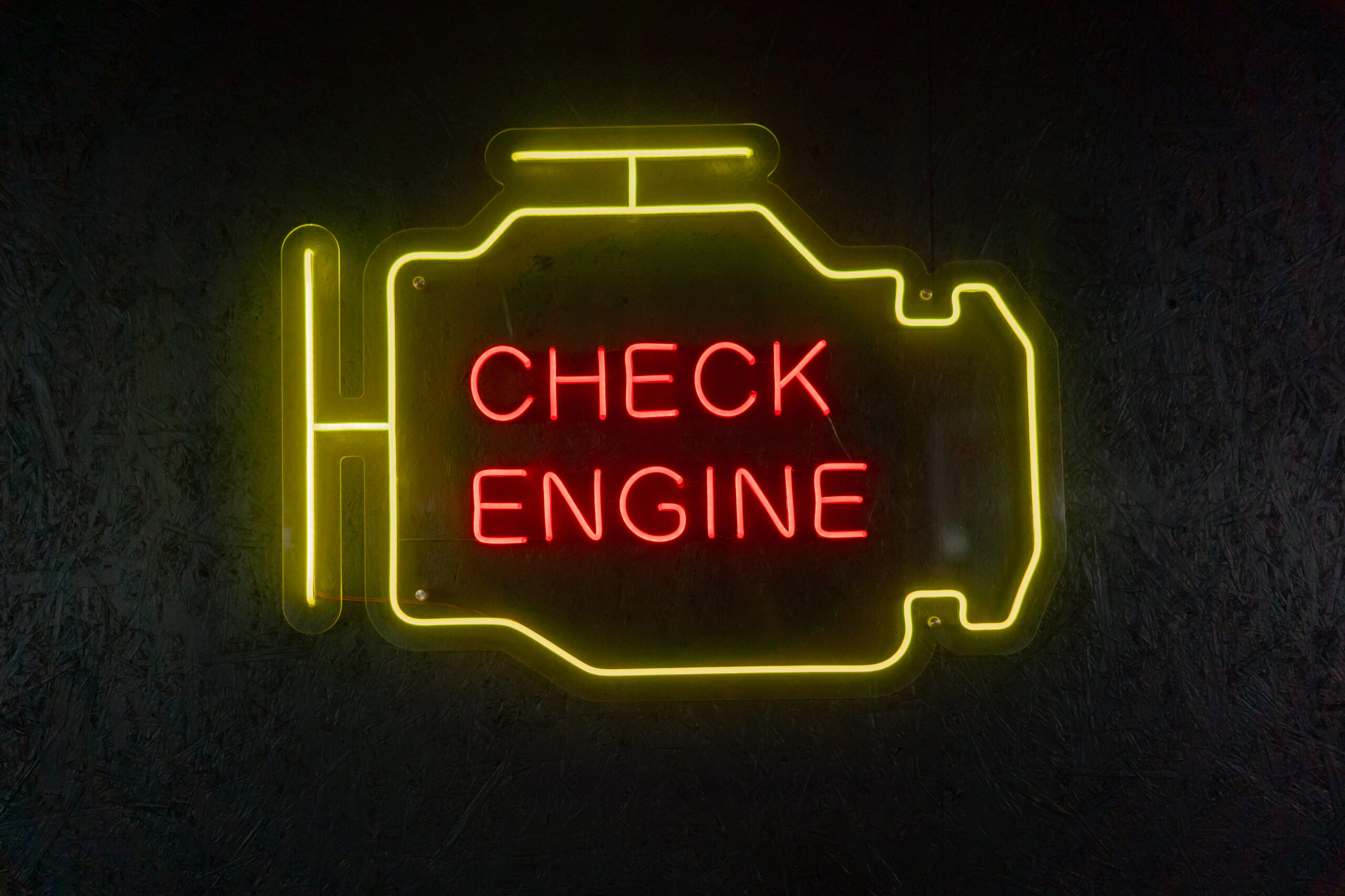 close-up At a service station a neon sign in the shape of an oil tank hangs on the wall yellow and red light